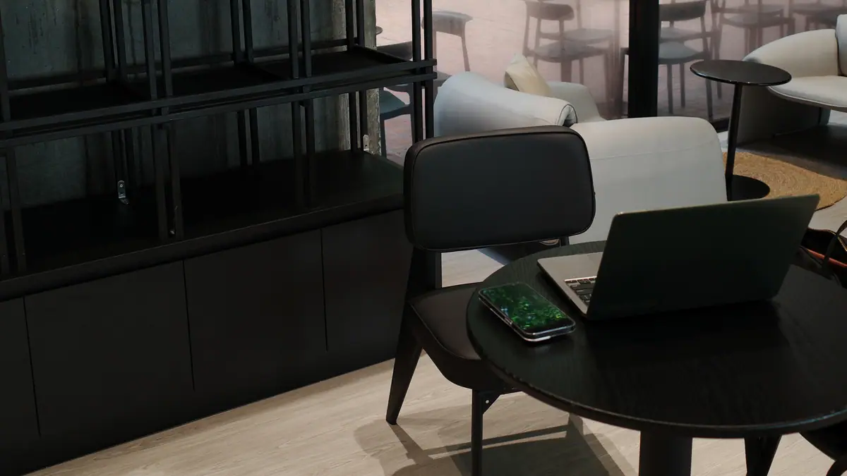 Modern workspace with a laptop on a compact table, lounge chair, and clean no-drill office setup
