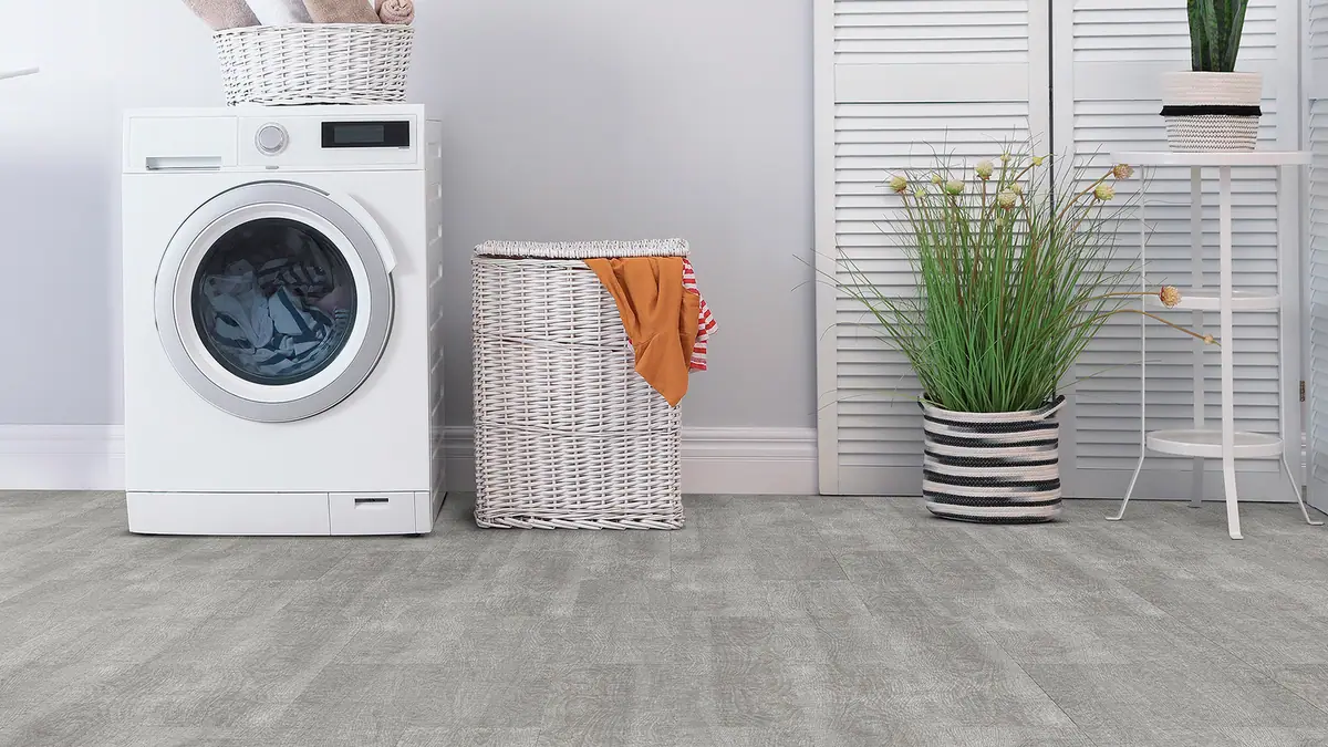 Bright apartment laundry nook with a rolling cart, baskets, and foldable drying rack arranged without wall drilling